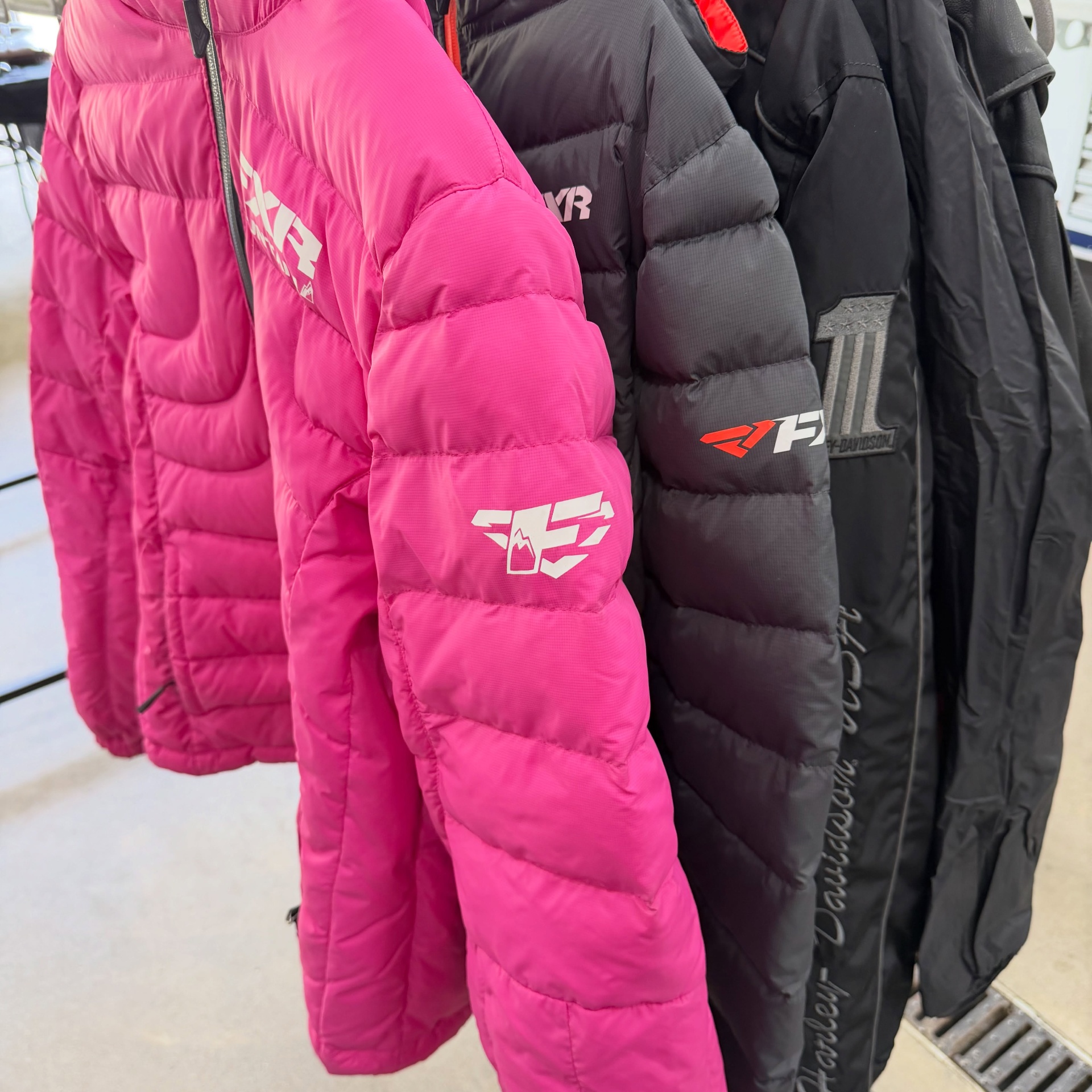 Donated branded puffer jackets on a rack